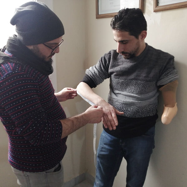 A student measuring the arm of the model patient