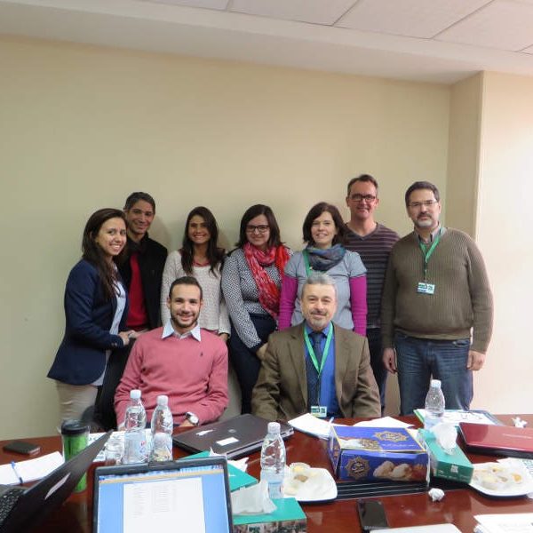 Human Study staff and local and international stakeholders group photo after a meeting, sitting at a table