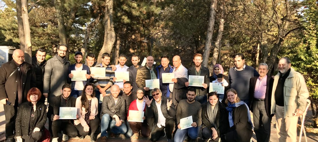 Students holding diplomas group photo with trainers, photographed outside